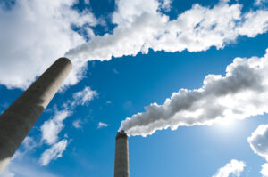 smoking industrial chimneys against a blue sky