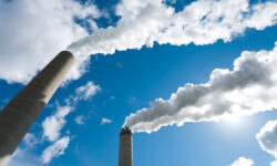 smoking industrial chimneys against a blue sky